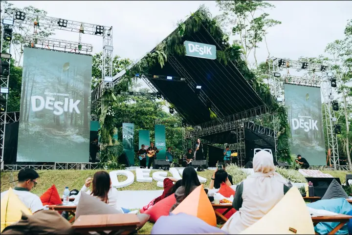 Panggung DESIK beratap dedaunan dengan penonton di beanbag warna-warni