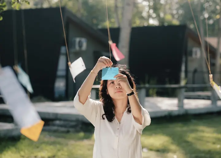 Pengunjung menggantungkan kertas harapan pada tali